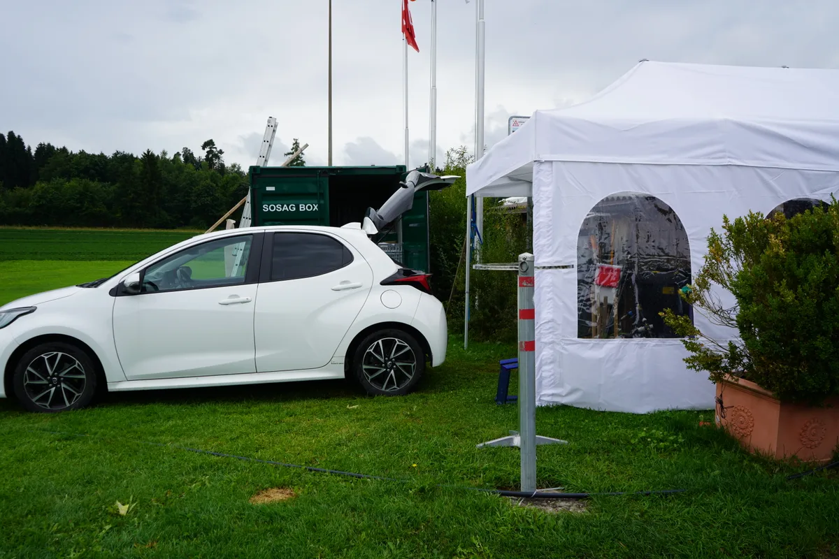 Ein Auto steht mit offenem Kofferraum direkt neben dem Festzelt.